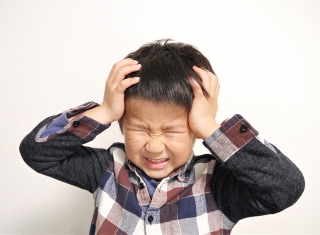 頭を抱えている男の子