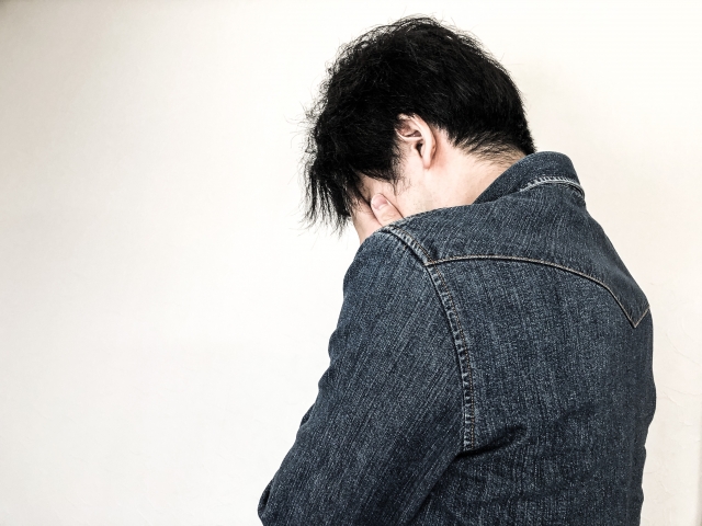 顔をおさえる男の人