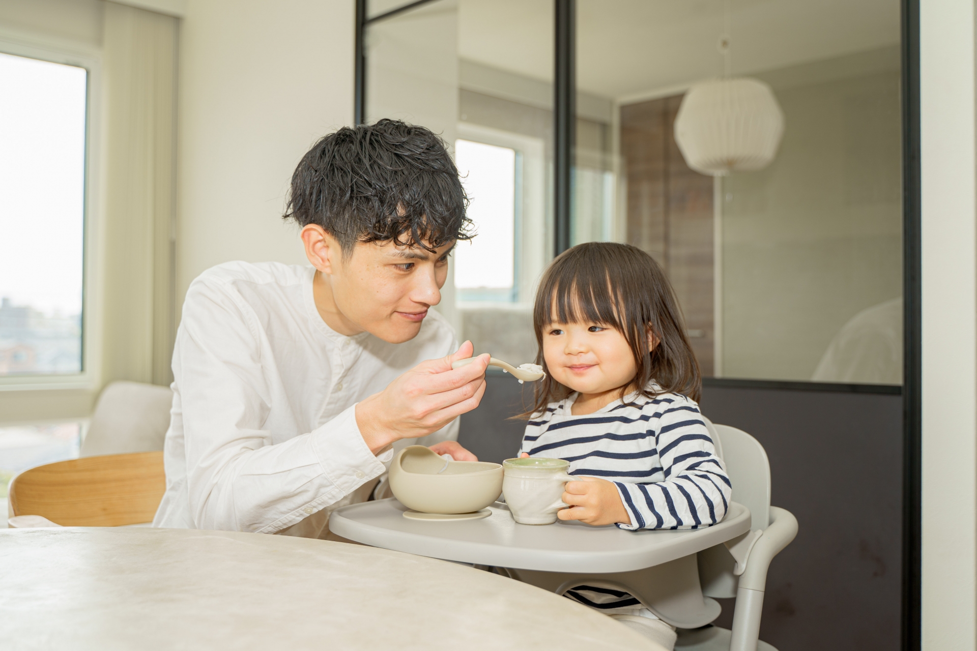 子どもにご飯をあげるお父さん
