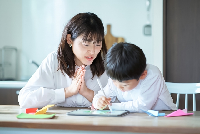 お母さんと何か書いている男の子