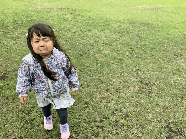芝生の上で泣いている女の子