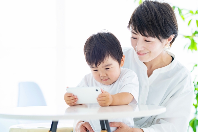 携帯を楽しそうに見ている男の子