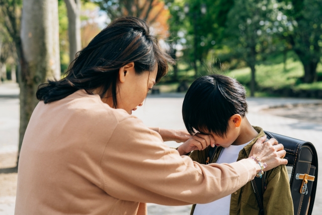 泣いている男の子を励ましているお母さん