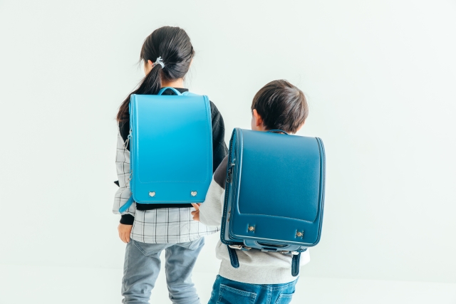 青いランドセルを背負う女の子と男の子