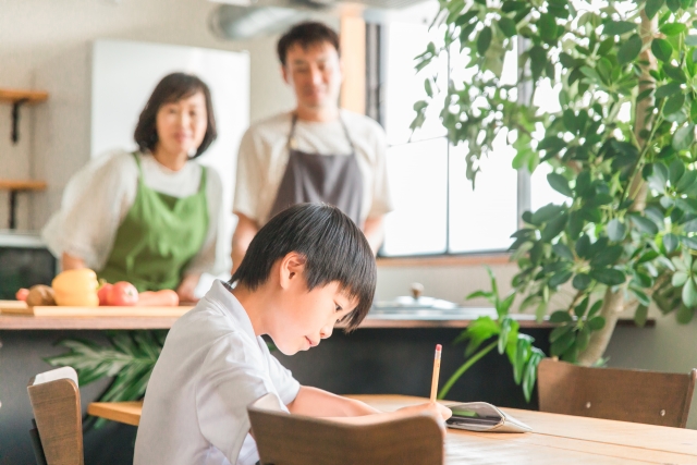 勉強する子供を見守る夫婦